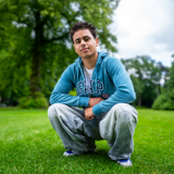 Lev zit gehurkt op het gras in een park