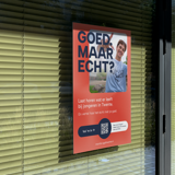 Campagneposter ‘Goed maar echt?’ op een raam
