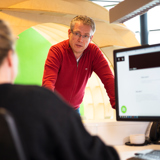 Arne staat bij bureau